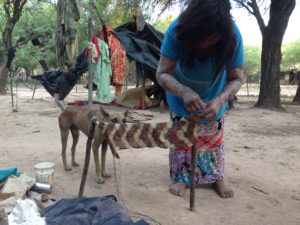 This woman is making a table runner (I think! haha) and in the background is her home.